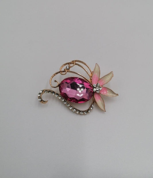 Guld broche med pink diamant